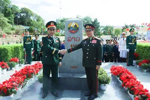 General Phan Van Giang (L) and General Khamliang Outhakaysone pose for a commemorative photo at Border Marker No. 460 on the Lao side. (Photo: SGGP)